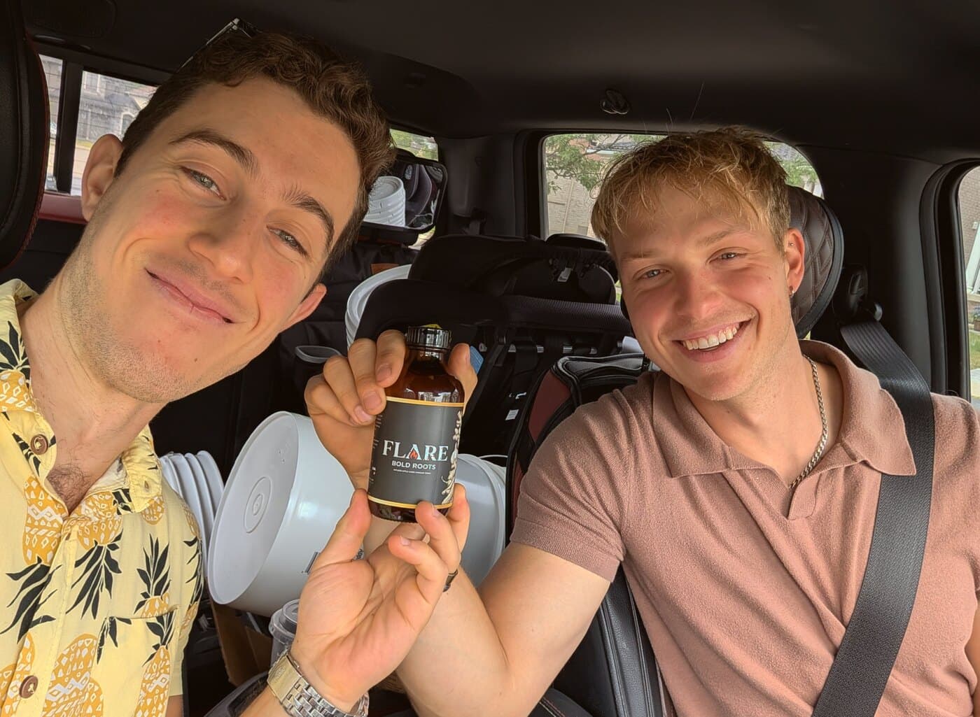 Claudio and Mitch holding a bottle of Flare Bold Roots fire cider